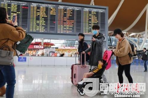 旅客帶著孩子前往辦票柜臺(tái)辦理登機(jī)手續(xù)。　殷立勤 攝