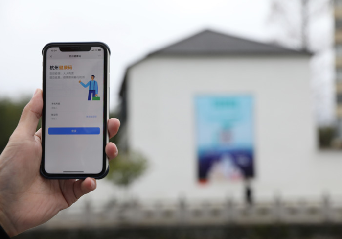 在浙江省杭州市臨安區(qū)天目山鎮(zhèn)，一名居民在“杭州健康碼”海報上掃碼申領個人二維碼。新華社發(fā)