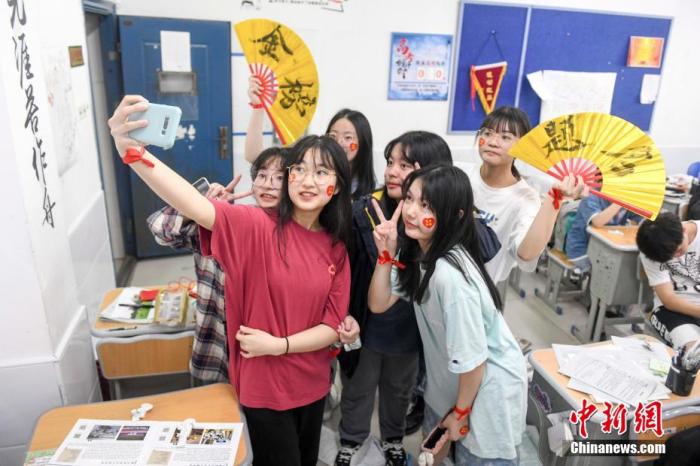 資料圖：6月6日，2021年高考前夕，湖南長(zhǎng)沙同升湖實(shí)驗(yàn)學(xué)校高三年級(jí)，考生們?cè)诮淌覂?nèi)合影。 楊華峰 攝